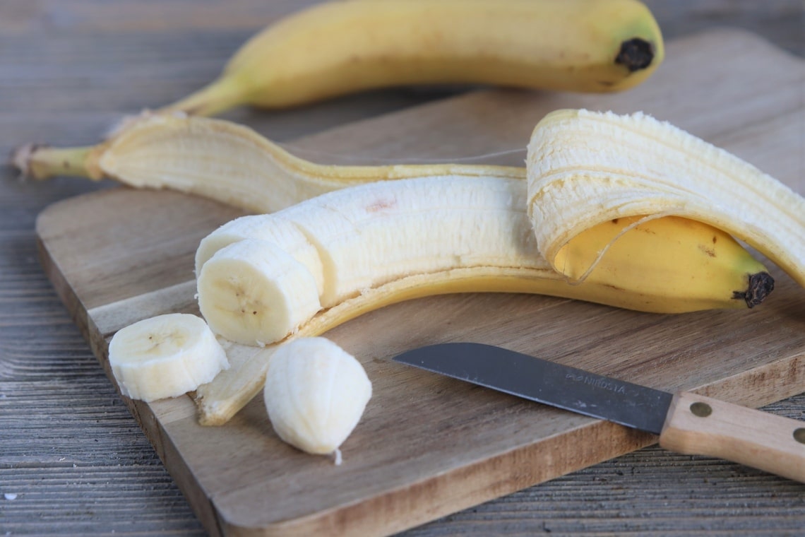 Banane auf Holzbrett in Scheiben geschnitten