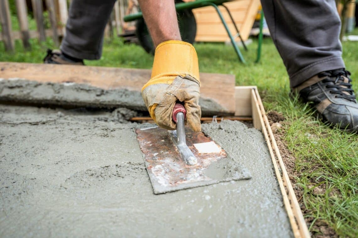 Mann verarbeitet frischen Beton