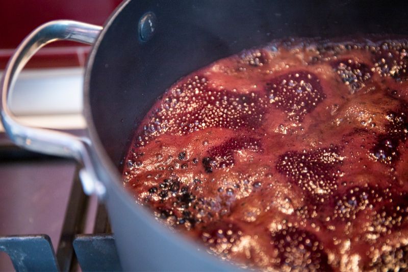 schwarze Holunderbeeren im Topf kochen