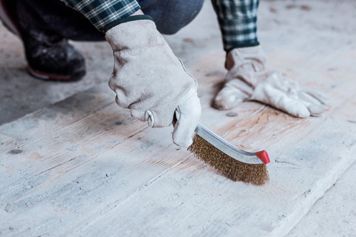 Zementrückstände von Holzboden mit Drahtbürste entfernen