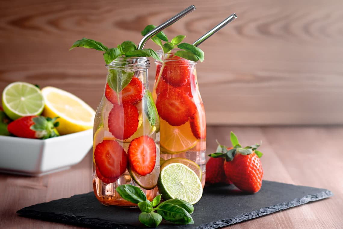 aromatisiertes Wasser im Glas mit Erdbeeren, Basilikum und Zitrone