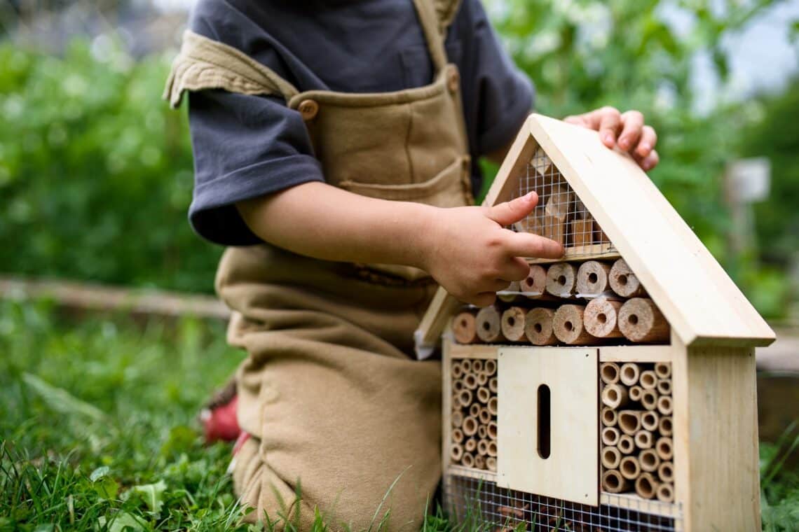 Kind mit Insektenhotel