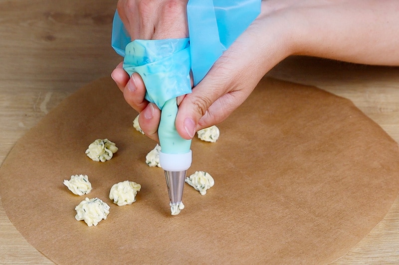 Dillbutter portionieren mit Tortenspritze auf Backpapier